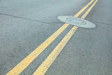 Double solid line and well cover on Highway