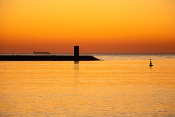 Cargo ship passing pier during sunset, Porto, Portugal. Golden hour