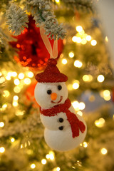 Toy little snowman on the fir-tree branch christmas and New Year tree decoration.