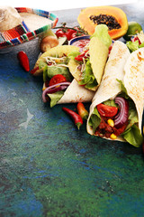 Mexican food, including tacos, guacamole, nachos and pepper on rustic table