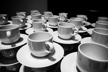 Stacked coffee cups with plates 02. Catering concept in black and white
