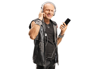Bald punk wearing leather vest listening to music with headphones