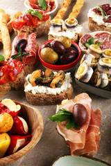 Appetizers table with italian antipasti snacks and wine in glasses. Brushetta or authentic traditional spanish tapas set, cheese variety