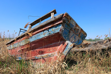 Fototapeta na wymiar The broken wooden boat is on land
