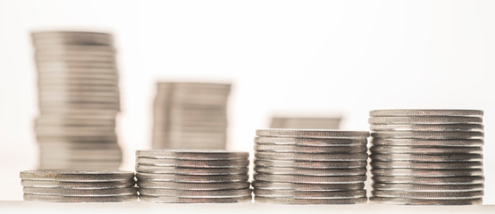columns of coins close-up on a white and colored backgrounds
