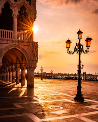 Doge's Palace at sunrise in Venice, Italy - Saint Mark square in an early morning with sun rays...
