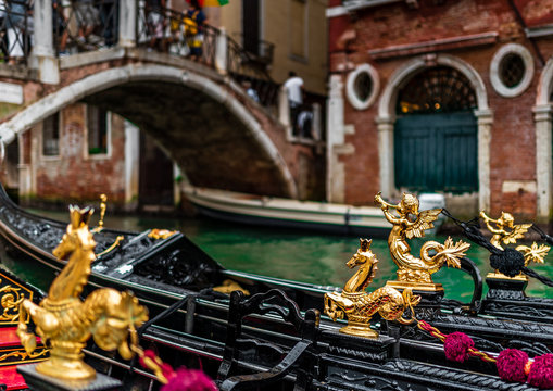 Gondola details with golden seahorse details in Venice, Italy. Traditional gondola on a popular water canal.