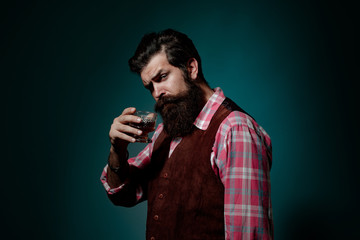 Bartender leather apron holding whisky cocktail in glass. Bearded and glass of whiskey.