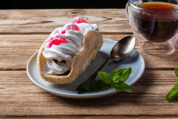 air cake on a saucer, hot tea on a wooden background
