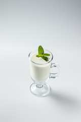 Ayran in a glass, fermented drink, sour milk, decorated with a leaf of mint