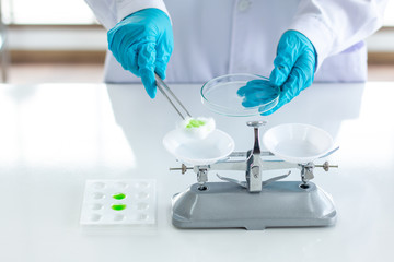 Fototapeta premium scientist wearing lab coat and gloves taking a sample in laboratory