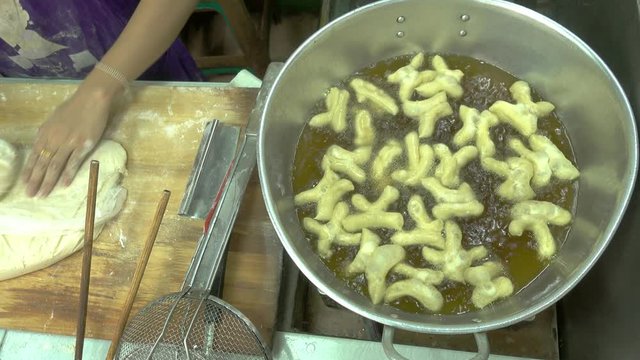 Top view fried bread stick cooking and hand prepare, The famous street food in the Asian countries.