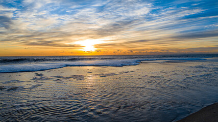Reflective pool sunrise at the beach along the New Jersey coastline.