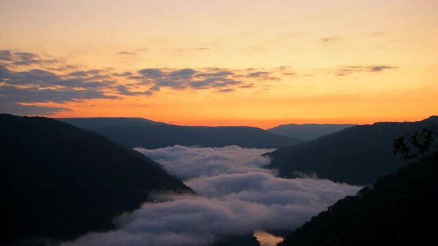 Mountains fog mist clouds moving timelapse of morning above new river gorge valley in Grandview Overlook, West Virginia during morning colorful sunrise 