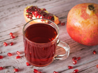 Top view of broken ripe pomegranates on a pink wooden table.