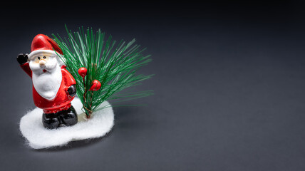 Christmas Santa Claus miniature toy decoration isolated on black gradient background.