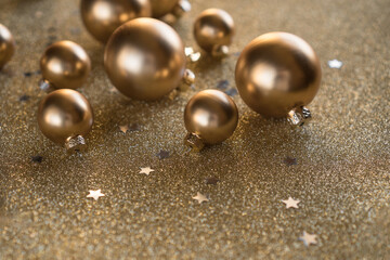 Golden Christmas toys and confetti are beautifully scattered on a shiny background.