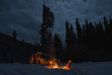 People camping under starry sky near campfire in winter in remote landscape in  Canada - 307538254