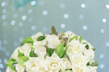 Close up of beautiful bouquet of white roses on blue background and blurred lights. Focus selective.