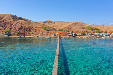 Aerial and top view the beautiful blue ocean and fisherman village at the remote island called Papagarang located in Komodo National Park, Indonesia.