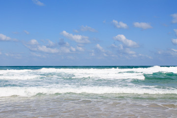 Sea foam on the sandy beach at Bat Yam, Israel. Waves on the blue stormy sea. Mediterranean coastline. Travelling picture. Turquoise water and sandy beach