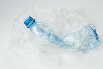 Plastic bottle with cellophane bag on a light background. The concept of ecology.