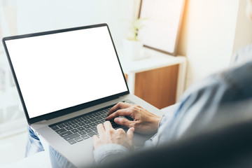 mockup image blank screen computer with blank white background for advertising text,hand man using laptop contact business search information on desk at home office.marketing and creative design