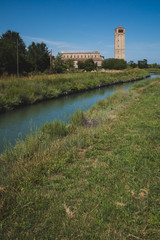 Fototapeta na wymiar Cathedral of Santa Maria Assunta and bell tower by river on island of Torcello, Venice, Italy