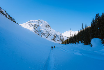 Backcountry ski touring in snow covered valley on sunny day in remote place in Canada
