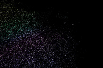 Neon glitter particles texture. Colorful sparkle dust isolated on black background