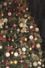 Сhristmas decoration on tree: white flowers, red bolls, gold cons.