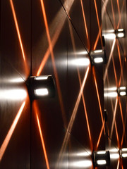 Abstract photo of an indoor theatre wall with lights and geometric designs  