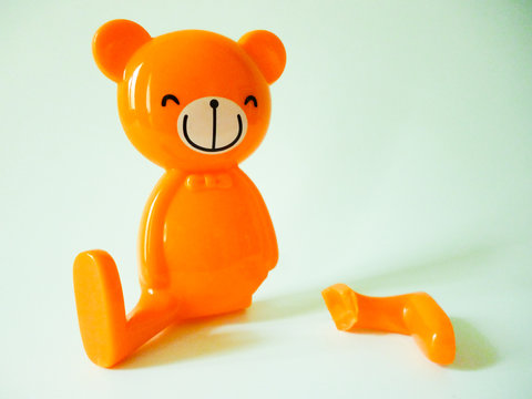 Smiley bear with broken leg, isolated, white background