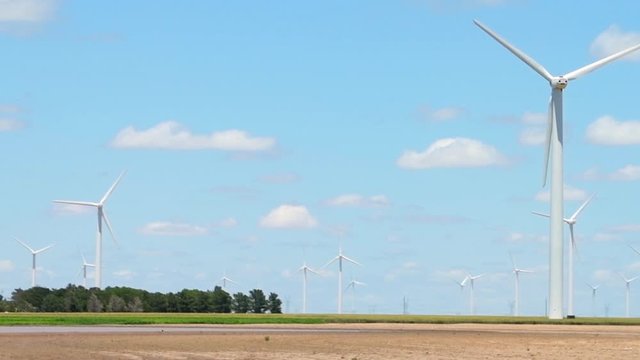 Wind turbines rural farm near Roscoe Texas or Snyder in USA in prairie with rows of many machines for energy panning driving pov in slow motion