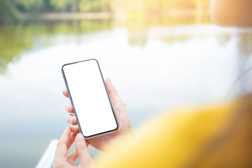 Mockup image blank white screen cell phone.men hand holding texting using mobile on desk at home office. background empty space for advertise text.people contact marketing business and technology 