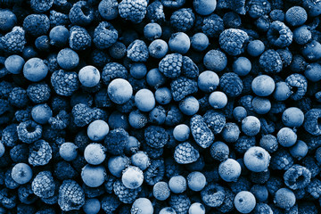 Frozen berries toned in classic blue color, top view. Close up.