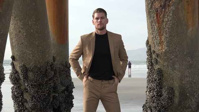 Portrait of a handsome man in a suit under an ocean pier