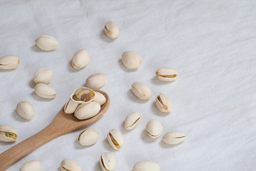 Pistachio nut in wooden bowl on white table background