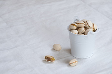 Pistachio nut in wooden bowl on white table background