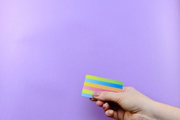 Demonstration of a multi-colored striped card in a hand on a purple background.