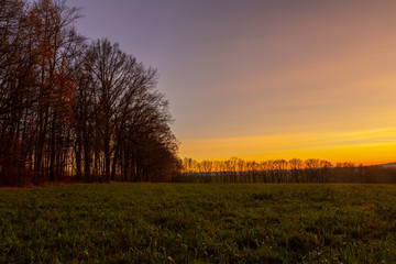Fototapeta na wymiar Cold winter dusk in Germany that shows this beautiful and colorful dusk in the field horizon.