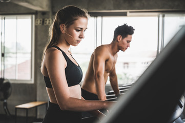 Fototapeta na wymiar Young couple Exercising by running on the treadmill To maintain good health always