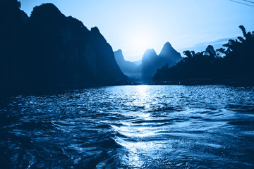 Fototapeta na wymiar Li River at the sunset, Guilin - Yangshou China. Tilt shift panorama of the river from water. Color of the year 2020. Main color trend concept.