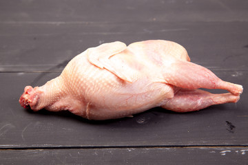 Raw quail meat on a wooden background