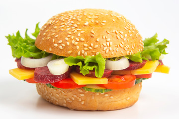 Hamburger with vegetables and sausage on a white background. Fast food and breakfast. Calories and diet.