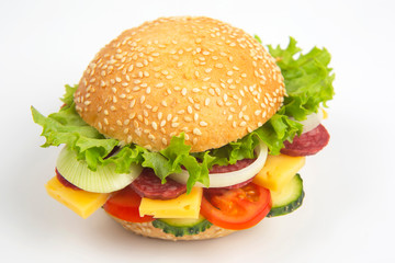 Hamburger with vegetables and sausage on a white background. Fast food and breakfast. Calories and diet.