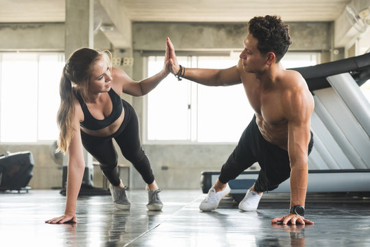 Couple love young fitness man and women workout exercise together. Weight training and cardio program concept. © Nopphon