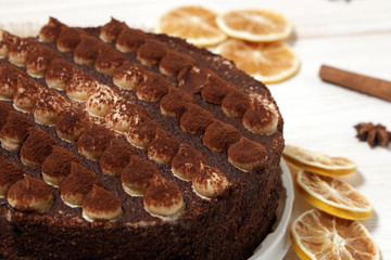 DeliciousTiramisu cake close-up on a white wooden background.