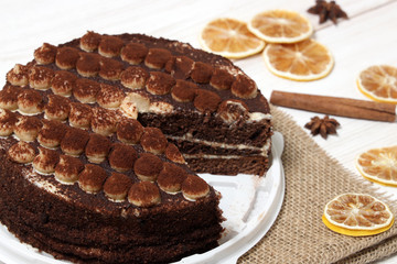 DeliciousTiramisu cake close-up on a white wooden background.