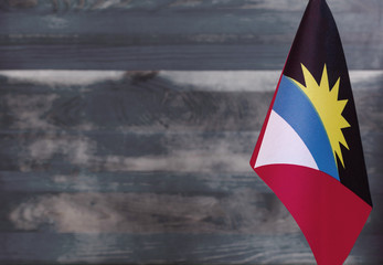 Fragment of the flag of Antigua and Barbuda in the foreground blurred light background copy space